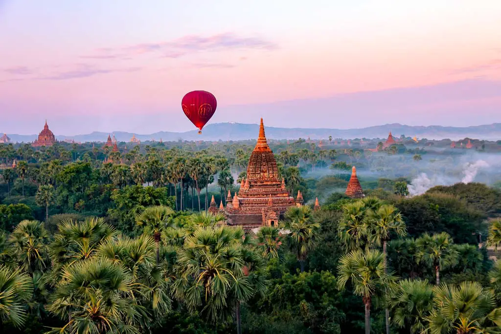 Hot air ballooning over forest and temples in Bagan, Myanmar