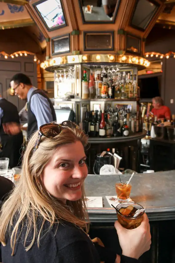 Woman holding a Cheers to Vieux Carré at the Carousel Bar.