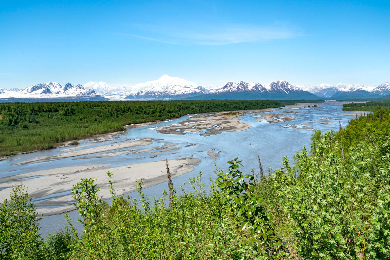 The braided Susitna River with tall, snow capped mountains in the background