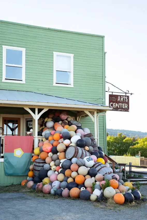 Art installation in Homer with bouys spilling out of green building