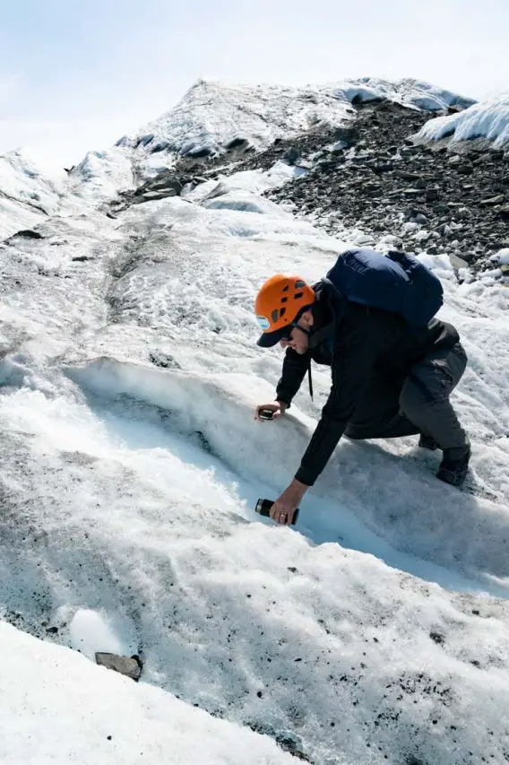 A man filling a water bottles with fresh glacial melt