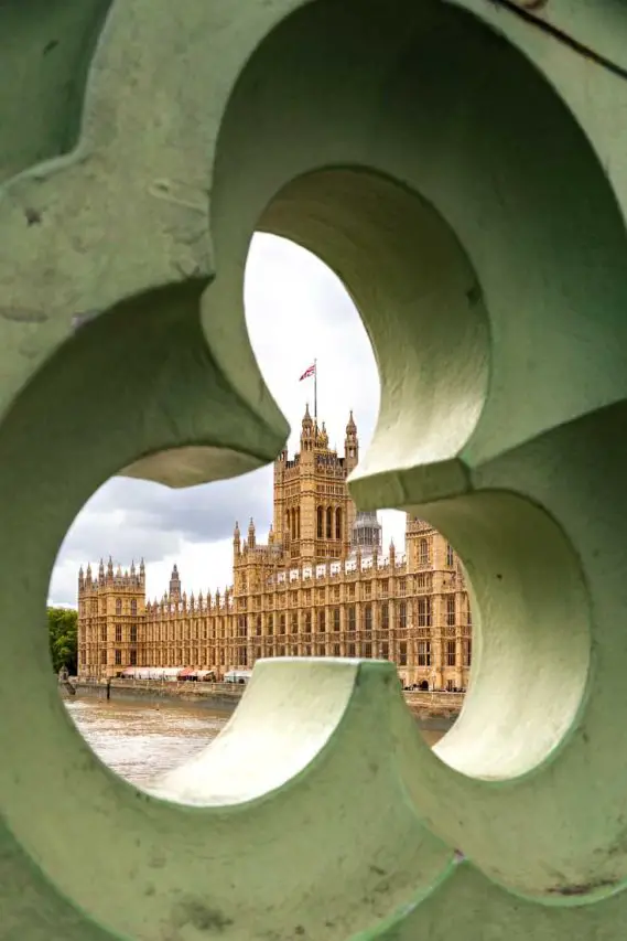 Houses of Parliament viewed through trefoil opening in Westminster Bridge