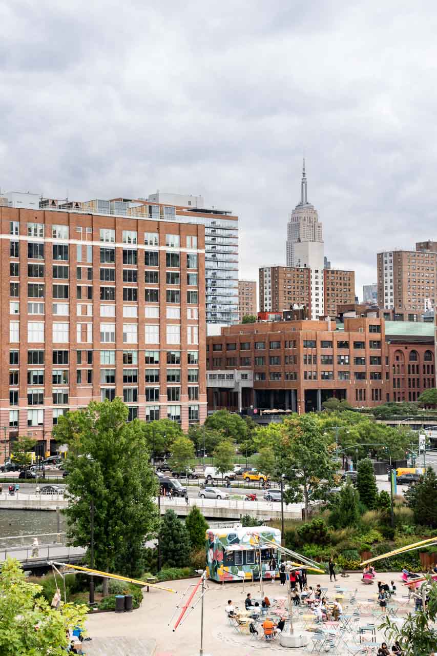 Plaza with food truck and city buildings in background