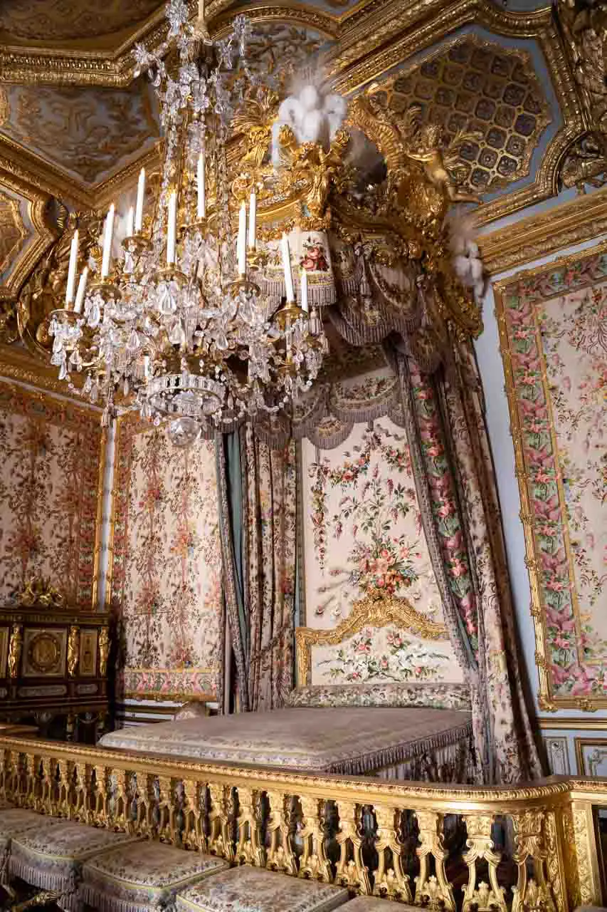 Queen's apartment with canopied bed rich with tapestry and a huge crystal chandelier
