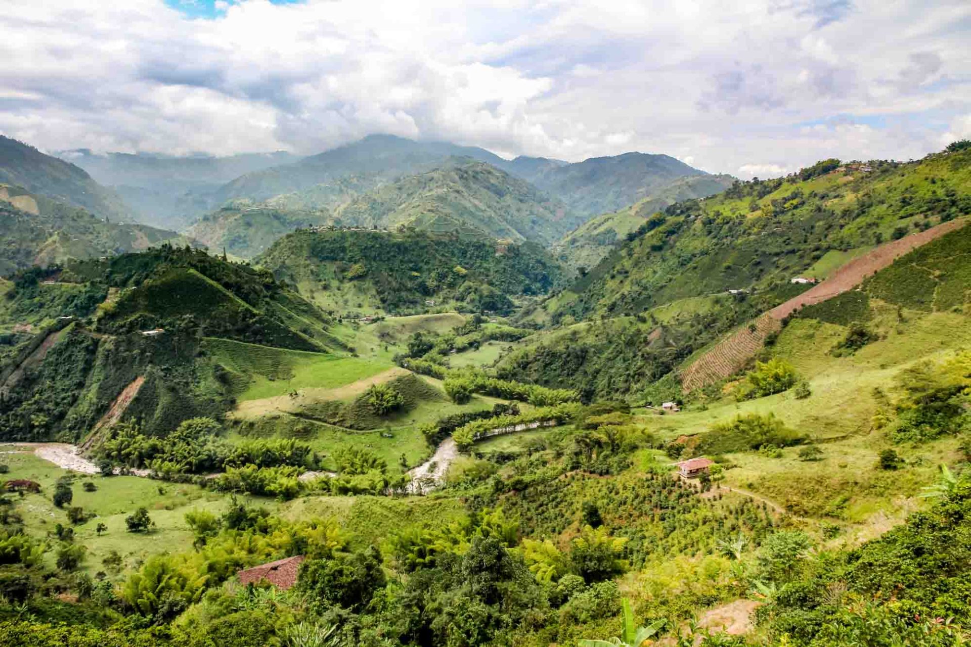 View over mountains and into a deep valley with river and farms