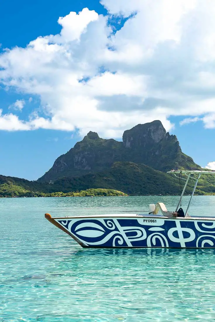 View of Mt Otemanu on Bora Bora, looking across lagoon with outrigger in foreground