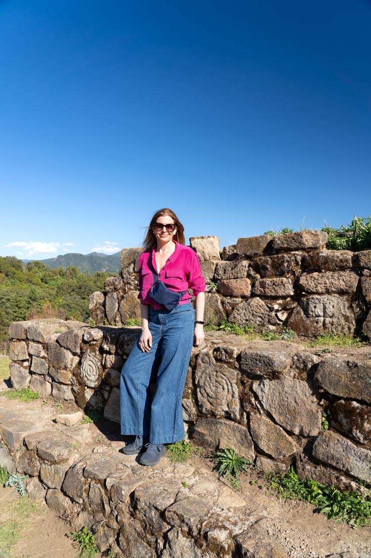 Woman standing on stone pyramid with petroglyphs either side
