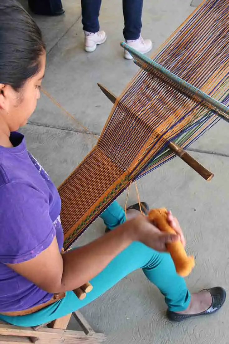 Woman weaving cotton on a backstrap loom