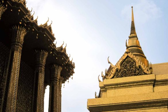 Gilded, Thai architecture against silhouette against partially cloudy sky