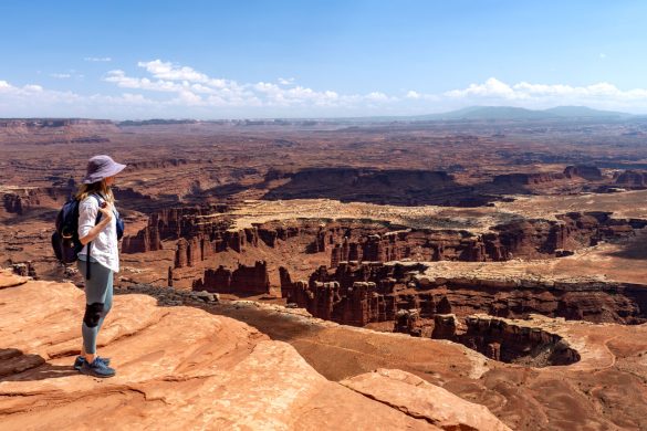 Female hiker looking out at view over Canyonlands National Park from Island in the Sky